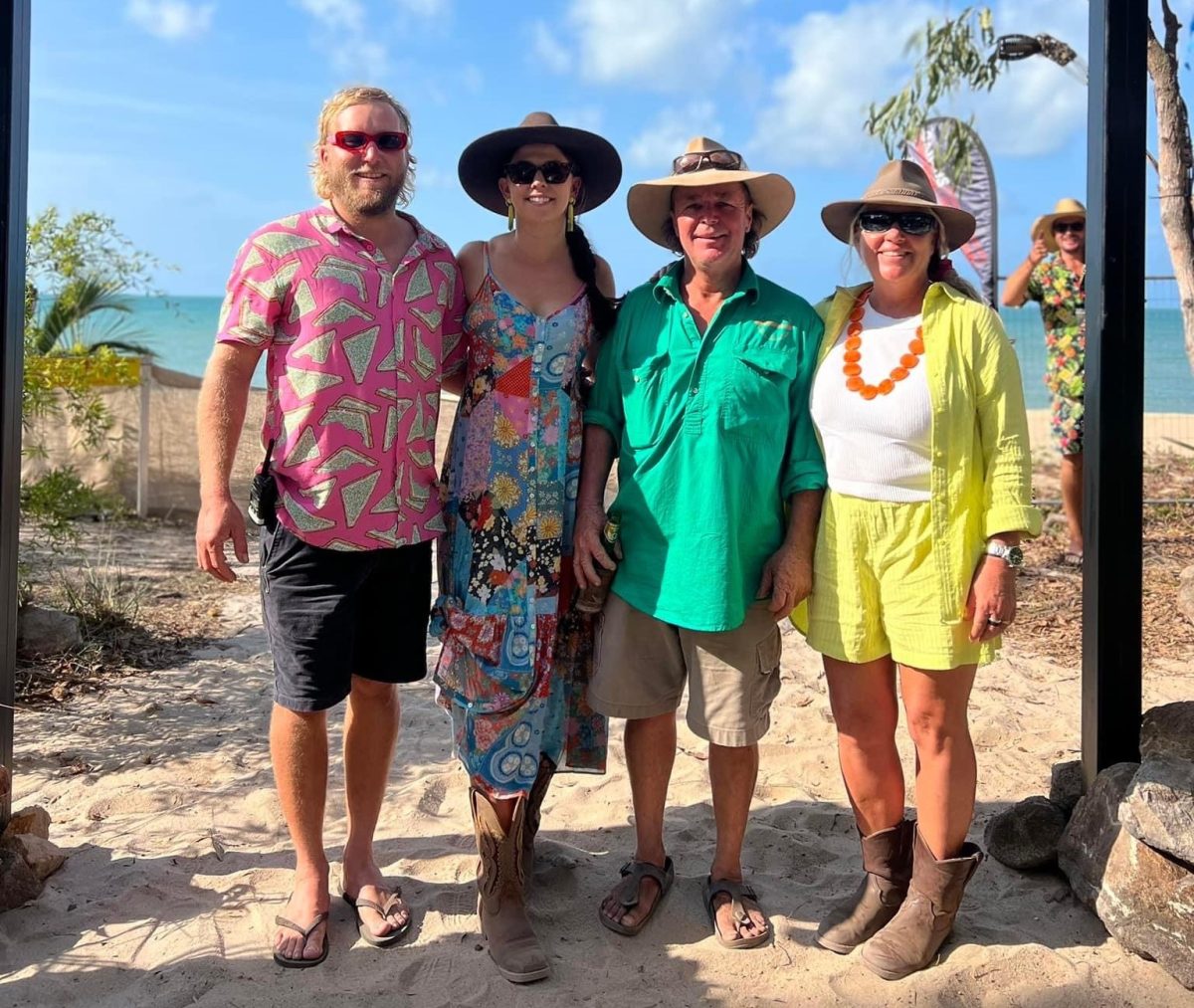 four people at beach in colourful clothes