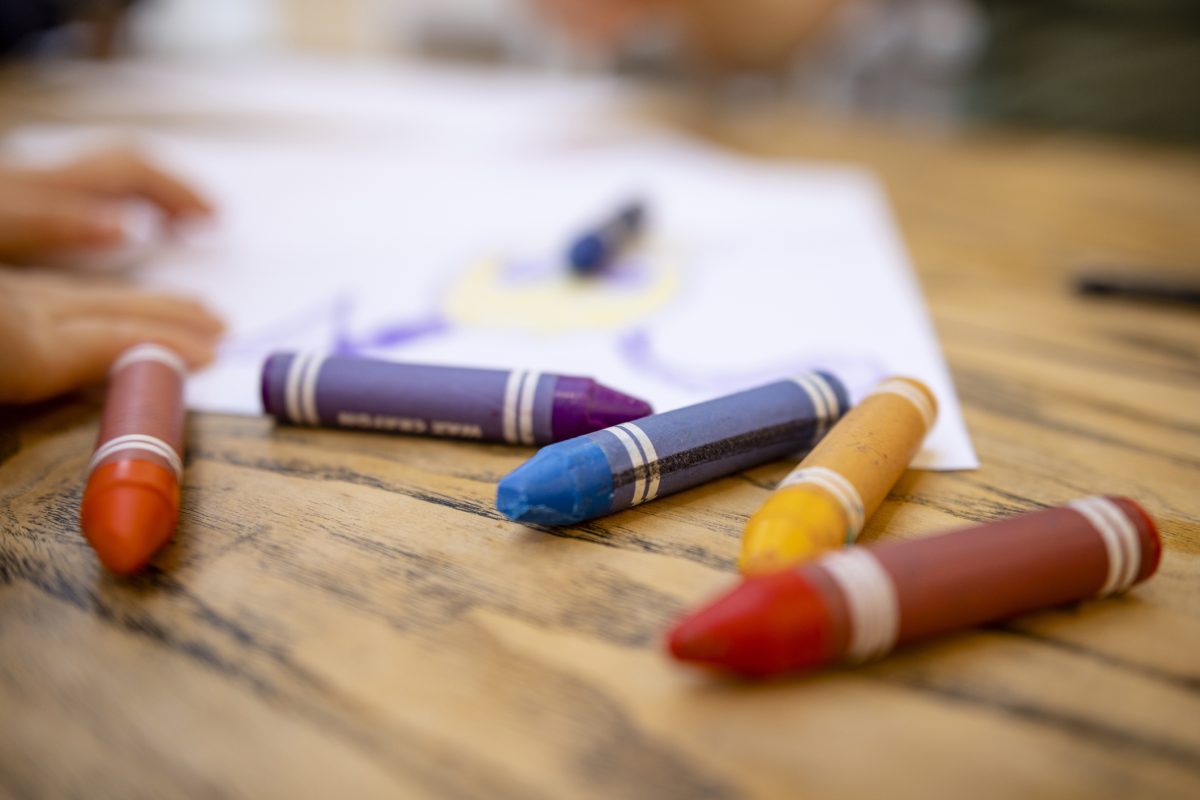 Crayons laid out on a wooden table.