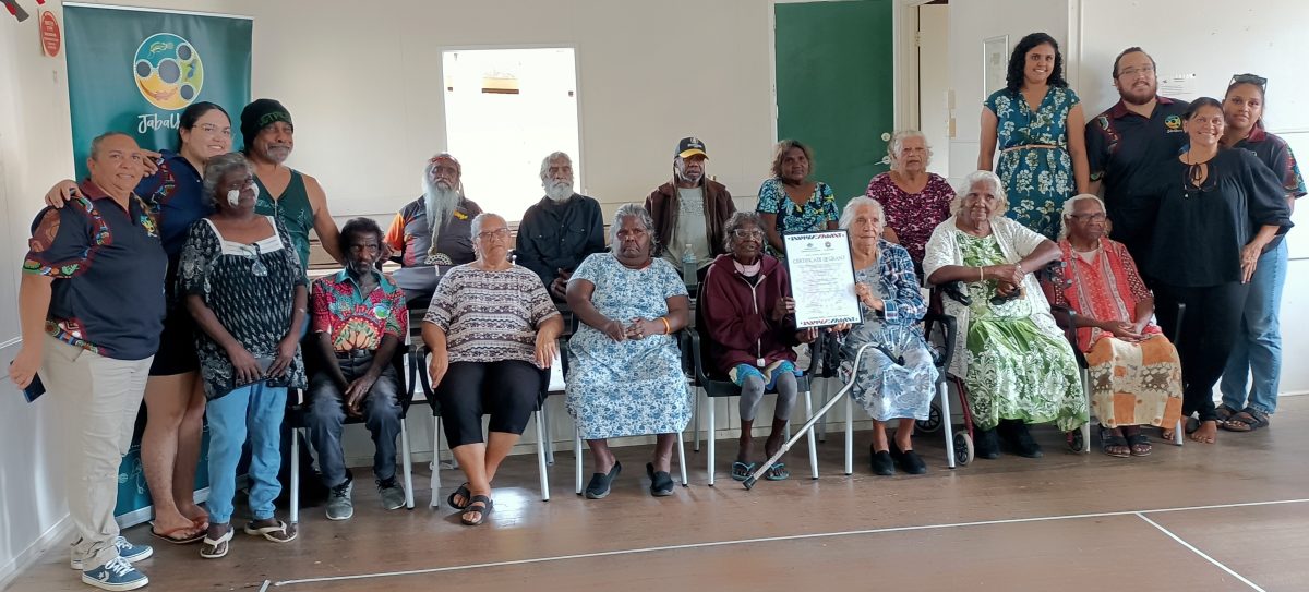 Elders and traditional owners with strong connection to Wawu Dimbi stand and sit together.