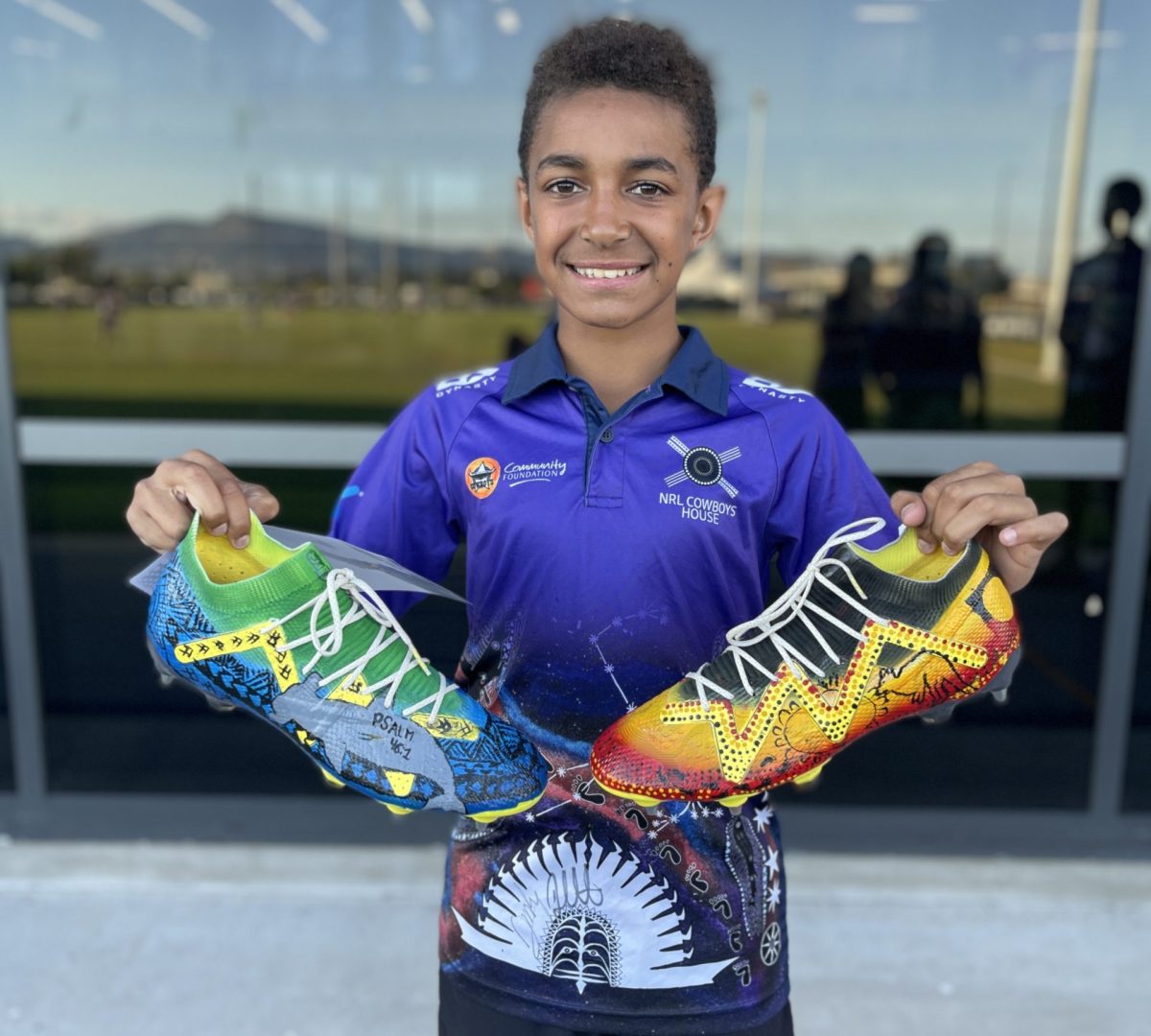 Zazward (Zazi) Banu holds up brightly coloured boots 