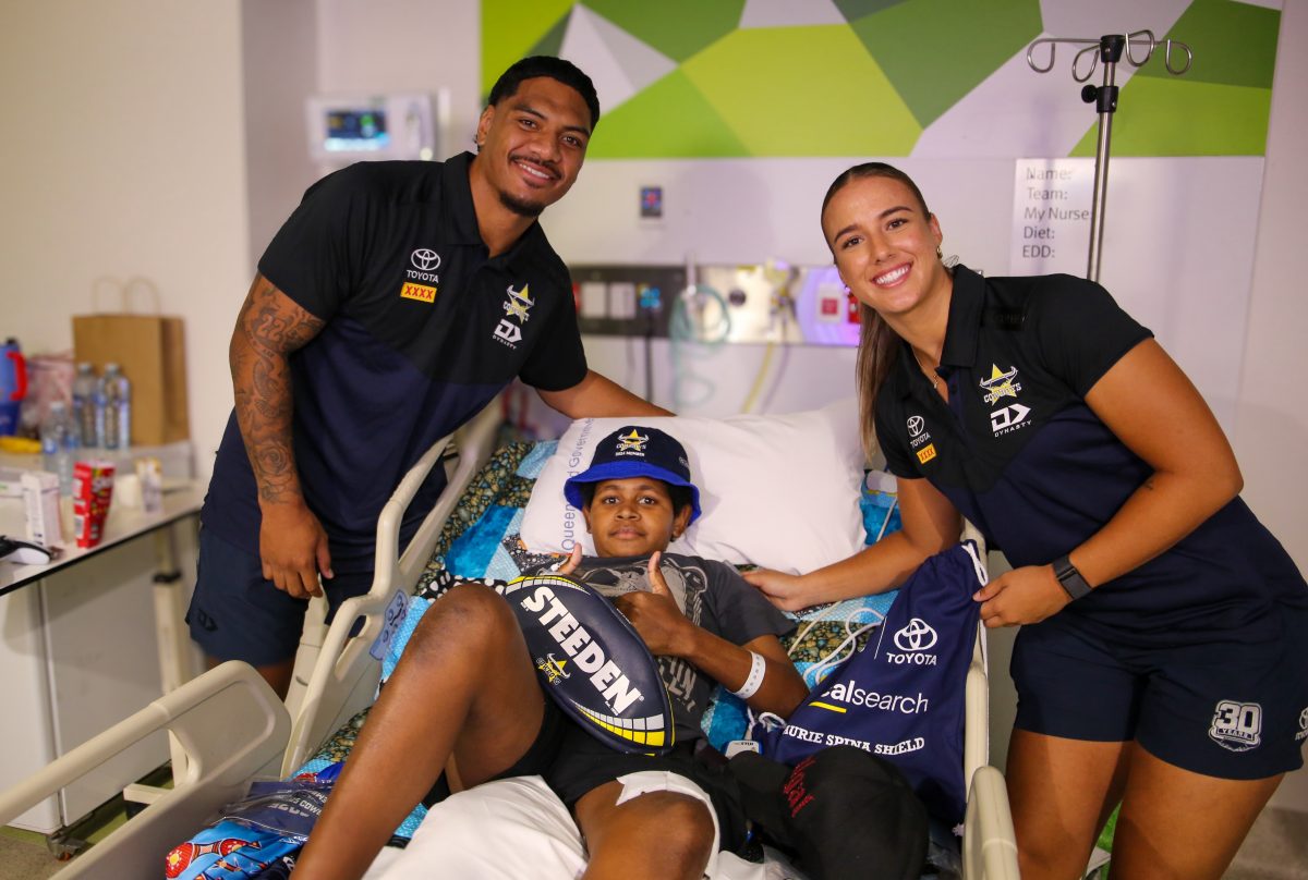 Thursday Island’s Samuel Nai welcomes Cowboys players Thomas Mikaele and Bree Chester to his hospital bed.